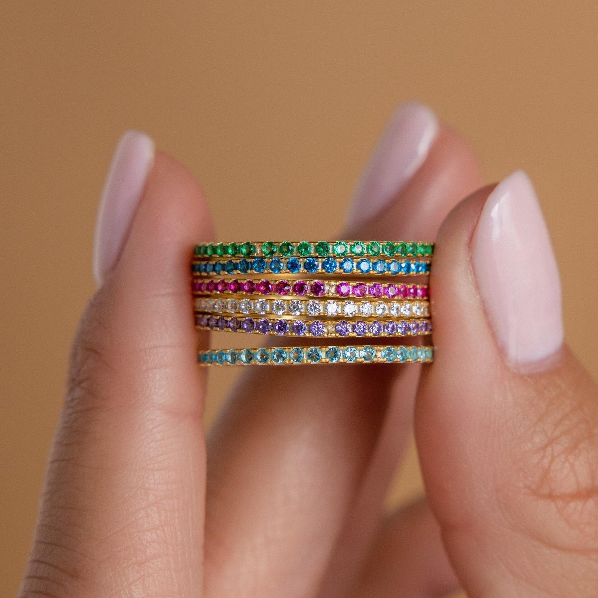 Birthstone eternity ring with colorful gemstone accents, shown on a clean neutral background