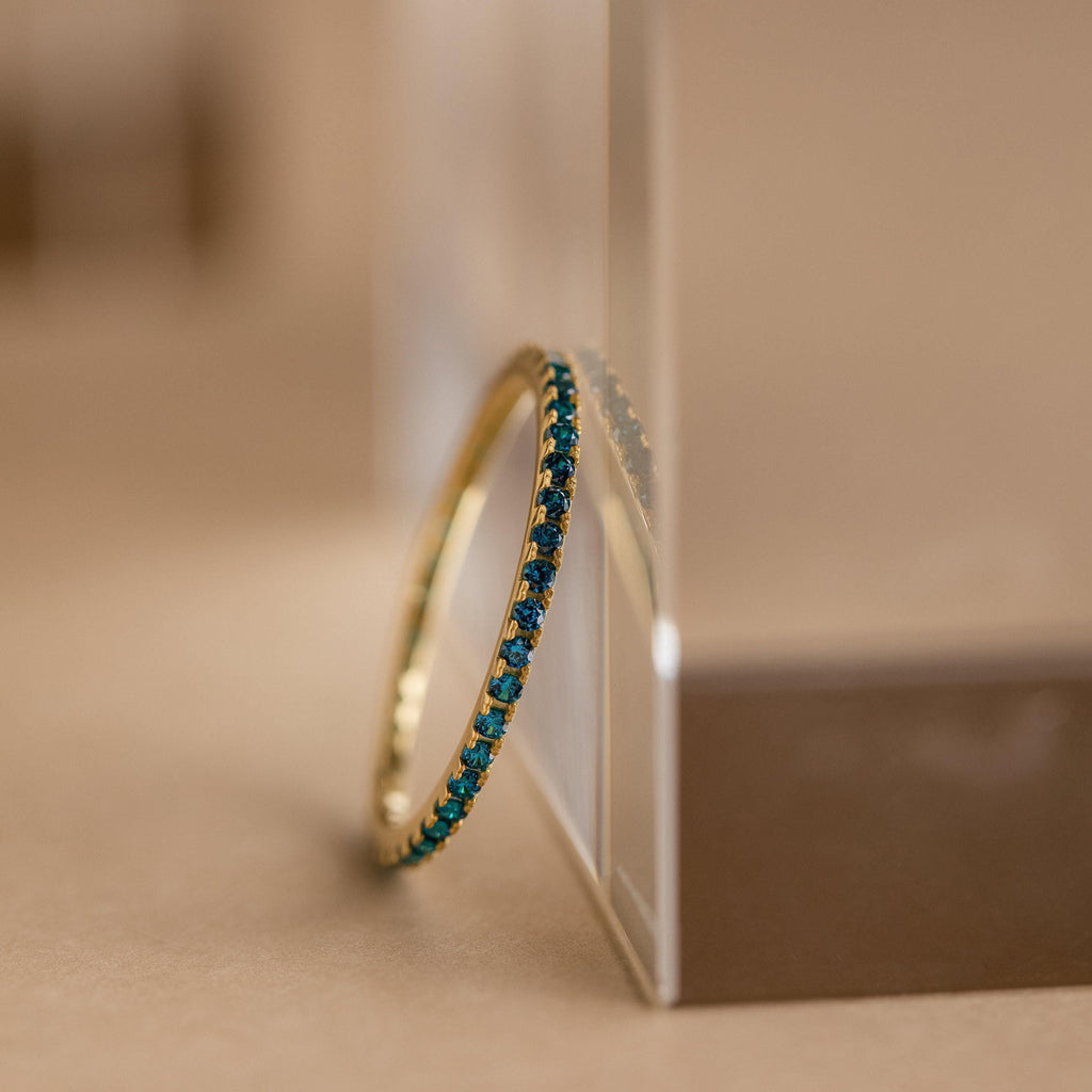 Birthstone eternity ring with colorful gemstone accents, shown on a clean neutral background