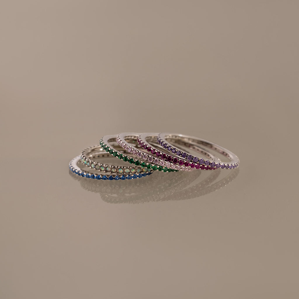 Birthstone eternity ring with colorful gemstone accents, shown on a clean neutral background