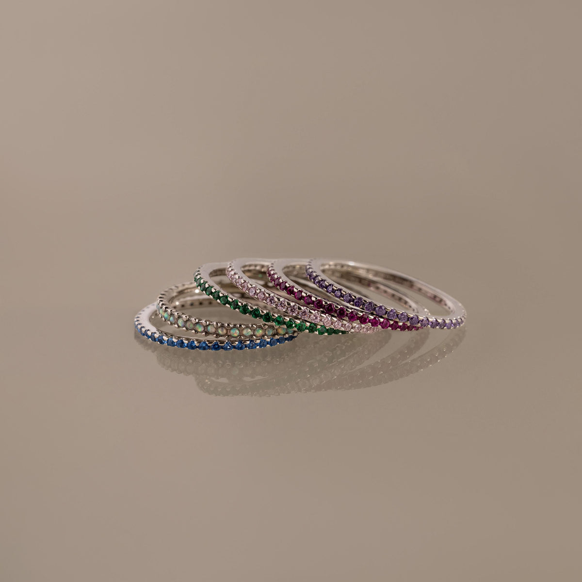 Birthstone eternity ring with colorful gemstone accents, shown on a clean neutral background