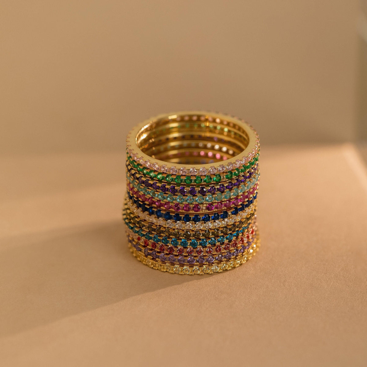 Birthstone eternity ring with colorful gemstone accents, shown on a clean neutral background